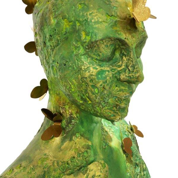 Trilokini 14 — mixed media figurative female bust sculpture by Romicon Revola with heavily textured green and gold surface and brass butterfly elements throughout, front view.